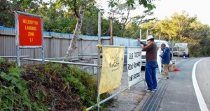 仮設テントが撤去された場所に新たに横断幕を取り付ける住民ら＝２０日、東村高江