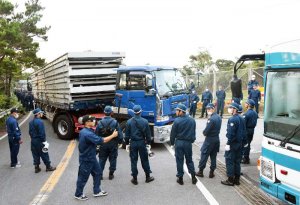 ヘリパッド建設資材とみられるものを続々と搬入する工事車両＝１２日午前６時１２分、東村高江