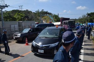 警察車両が前後を警備する中、Ｎ１地区表側出入り口から入るトラック＝２８日午前、東村高江
