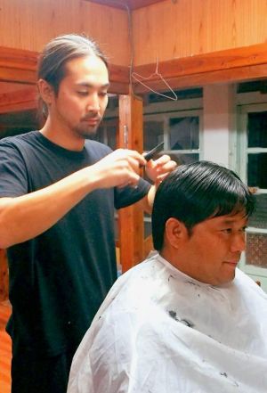 「島の美よう室」を継いだ神保了さん。子どもからお年寄りまで、幅広い世代の髪を切る=6日、渡名喜村(笹口真利衣通信員撮影)