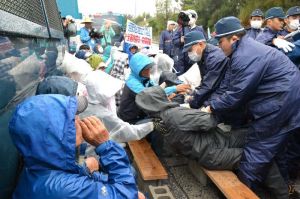 工事用ゲート前に座り込んだ市民らを強制排除する県警機動隊=18日午前9時ごろ、名護市辺野古の米軍キャンプ・シュワブ前