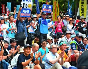 謝花喜一郎副知事のあいさつを音声中継で聞き、拍手を送る東京の集会参加者=11日、東京都豊島区の東池袋中央公園