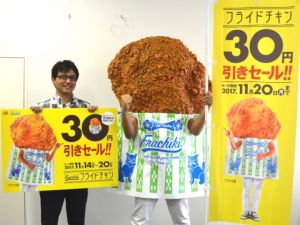 リニューアルしたフライドチキンの割引セールをPRするフラチキ先輩と沖縄ファミリーマート広報・マーケティング室の與座尚志課長=13日、沖縄タイムス社