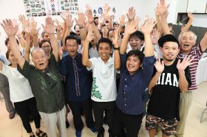 トップ当選を確実にし、支持者と万歳で喜ぶ自民現職の奥間亮さん(前列中央)=10日午前0時42分、那覇市高良(喜屋武綾菜撮影)