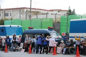 新基地建設に反対し、座り込んで抗議を続ける市民ら=15日午前10時30分、名護市辺野古・米軍キャンプ・シュワブゲート前