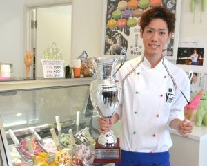 国際コンクールで準グランプリに輝いたジェラートとトロフィーを手に喜ぶ米盛勝也さん=2日、宜野湾市嘉数・「la Vous」