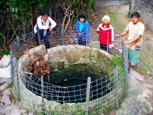 「西又がー」を見つめる(右から)仲尾区の宮里達也書記、金城のり子さん、光行八重子さんと玉城清市区長=名護市