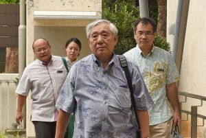 上告理由書と上告受理申立理由書を提出するため福岡高裁那覇支部に入る竹下勇夫弁護士(中央)ら=3日、那覇市