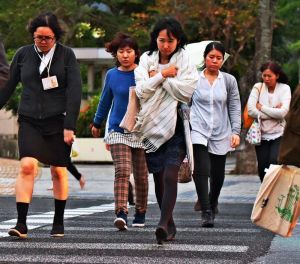 北風が吹く中、足早に横断歩道を渡る人たち=27日午後5時すぎ、那覇市久茂地(渡辺奈々撮影)