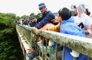 高江橋の欄干にしがみつく住民を排除する機動隊=7日、東村高江