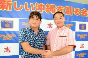 県知事選に出馬する佐喜真淳氏(右)の推薦を決め、握手する安里氏=20日、那覇市のいとみね会館
