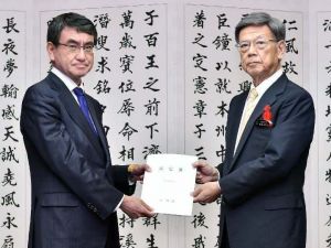 翁長雄志知事(右)から基地問題解決へ向けた要望書を受け取る河野太郎外相=2日午後、県庁