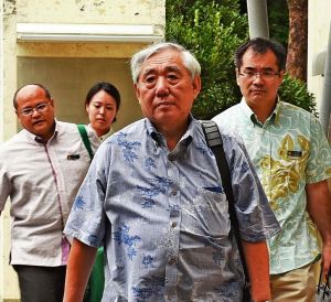 上告理由書と上告受理申立理由書を提出するため福岡高裁那覇支部に入る竹下勇夫弁護士(中央)ら=3日、那覇市