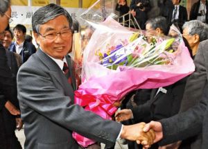 退任式を終え、職員の花道を通る稲嶺進氏=7日、名護市役所