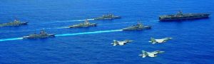 沖縄県東沖を航行する米原子力空母カール・ビンソン(先頭)と海上自衛隊の護衛艦(手前の2隻)など。飛行するのは共同訓練する航空自衛隊の戦闘機(先頭)と空母の艦載機=28日(航空自衛隊提供)