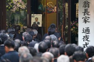 通夜が始まる前、会場入り口に並ぶ参列者=10日午後、那覇市・大典寺(下地広也撮影)