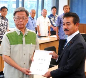佐藤外務副大臣に日米地位協定の見直し要請書を渡す翁長知事(左)=12日、外務省