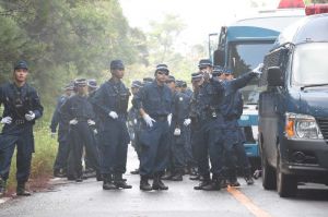 市民が止めた車を排除するため打ち合わせをする機動隊員ら=10日午前8時15分ごろ、国頭村安波