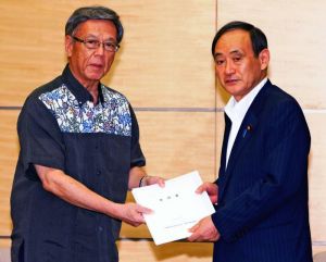 菅官房長官(右)に沖縄の基地負担軽減の要請書を手渡す沖縄県の翁長雄志知事=9日午後、首相官邸