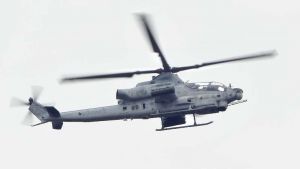 普天間飛行場から再び飛行し名護市上空を飛ぶ、読谷村に8日不時着したAH1攻撃ヘリ=9日午後3時55分