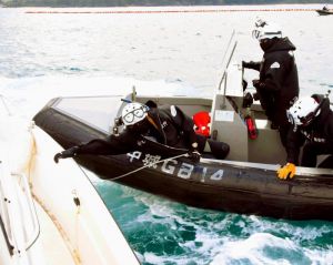 動こうとする抗議船につかまる海上保安官=日午後3時すぎ、名護市辺野古の米軍キャンプ・シュワブ沖