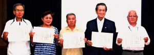 「留年許可」の表彰状を誇らしげに見せる(右から)平田さん、比屋根さん、米須さん、仲村さん、比嘉さん=25日、北中城村・大城区公民館