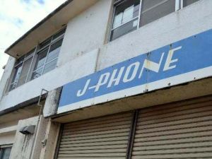 携帯電話の歴史を感じさせる「J―PHONE」の看板=沖縄市住吉