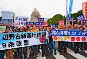 国会を背に、辺野古の新基地建設反対を訴える市民ら=26日、東京都千代田区の国会正門前