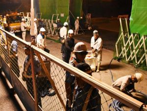 工事用の仮フェンスを張り、フェンス拡張作業が始まった=15日午前0時42分、名護市辺野古の米軍キャンプ・シュワブゲート前