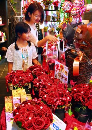 母の日を前にプレゼント用の花を選ぶ親子=12日、那覇市安里・フラワーショップトーバル(落合綾子撮影)