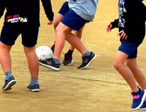 55日ぶりに使用が再開された運動場でサッカーをする子どもたち=6日午前、宜野湾市・普天間第二小学校