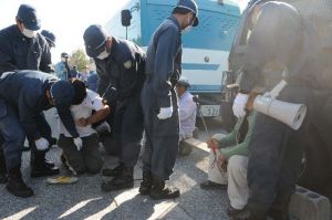 新基地建設を阻止しようと米軍キャンプ・シュワブ工事用車両専用ゲート前に座りこむ市民と排除する機動隊員=6日午前、名護市辺野古