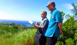 展望台から海軍基地アプラ港を視察する翁長雄志知事(右)=11日、米領グアム(県提供)