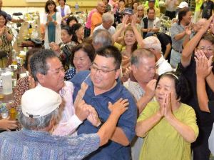 初当選を決め、支持者から祝福される島袋力さん(中央)=9日午後11時20分、名護市・数久田体育館(古謝克公撮影)