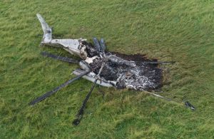 牧草地で炎上し、大破した大型輸送ヘリCH53E=12日午前、東村高江(小型無人機から)