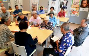 新基地建設用資材の海上運搬業者に、本部港を使わせないよう本部町職員(手前右端、右から2人目)に求める市民ら=9日、本部町役場