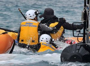 海上保安庁の隊員が海に飛び込み、オイルフェンス設置に抗議する市民を捕まえる=4日午後3時23分、名護市辺野古のキャンプ・シュワブ沖(下地広也撮影)