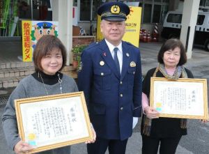 人命救助で表彰された沖縄タイムス大里南販売センターの平良まりよさん(左)、上地栄子さん(右)と仲地隆穂与那原署長=16日、同署