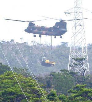 米軍北部訓練場の上空から重機を搬入する陸上自衛隊CH47ヘリ=13日午前9時15分、東村と国頭村の境付近
