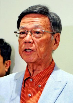 米領グアムの視察を終えて帰任し、記者団の質問に答える翁長雄志知事=13日、那覇空港