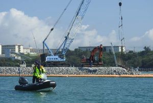 砕石の投下が進む「K4」護岸建設現場と、抗議船の退去を求める船=14日午前9時15分、名護市辺野古の米軍キャンプ・シュワブ沖