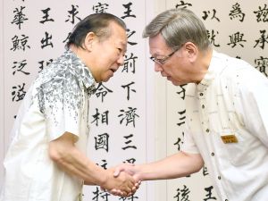 握手を交わす沖縄県の翁長雄志知事(右)と自民党の二階俊博幹事長=14日午前、沖縄県庁
