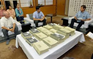 謝花喜一郎副知事(右)に、辺野古新基地建設の是非を問う県民投票の署名と声明を提出した元山仁士郎氏(中央)=5日午前