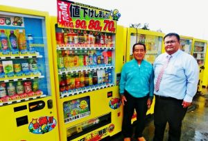 関東圏で約千台の格安自販機を展開するミリオンの平川良夫社長(左)と平川隆行専務取締役=うるま市昆布の沖縄本社