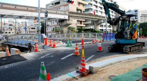 30日正午の久美橋開通に向けて、作業を進める工事関係者=29日午後5時前、那覇市久茂地