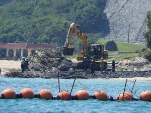 米軍キャンプ・シュワブの海岸に重機を使って石を敷く作業員=3日午後、名護市辺野古(下地広也撮影)