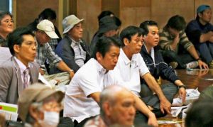 市民集会に参加し、参加者と共に登壇者らの意見を聞く中山義隆市長(中央、奥沢秀一通信員撮影)