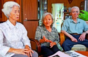 孤児として生きた戦後を振り返る山川信子さん(中央)と、叔母の仲間春子さん(左)、叔父の小橋川萬三さん=20日、金武町の山川さん宅