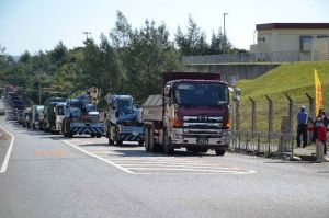 米軍キャンプ・シュワブに入るダンプカーなどの列=19日午前9時半ごろ、名護市辺野古