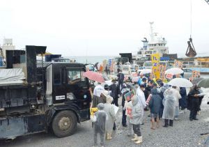 辺野古新基地建設用の砕石を搬入するダンプカーの前に立ちはだかり、新基地建設に抗議する市民ら=4日、本部港塩川地区